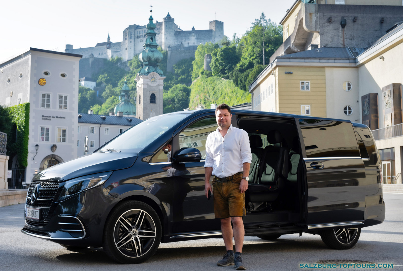 Frequently asked questions about private tours in Salzburg. Licensed Austria Guide Eugene with his luxury Mercedes-Benz V-Class in the historic Old Town. Private Austria Guide Eugene standing next to his luxury Mercedes-Benz V-Class minivan in the Old Town of Salzburg, providing individual travel services.